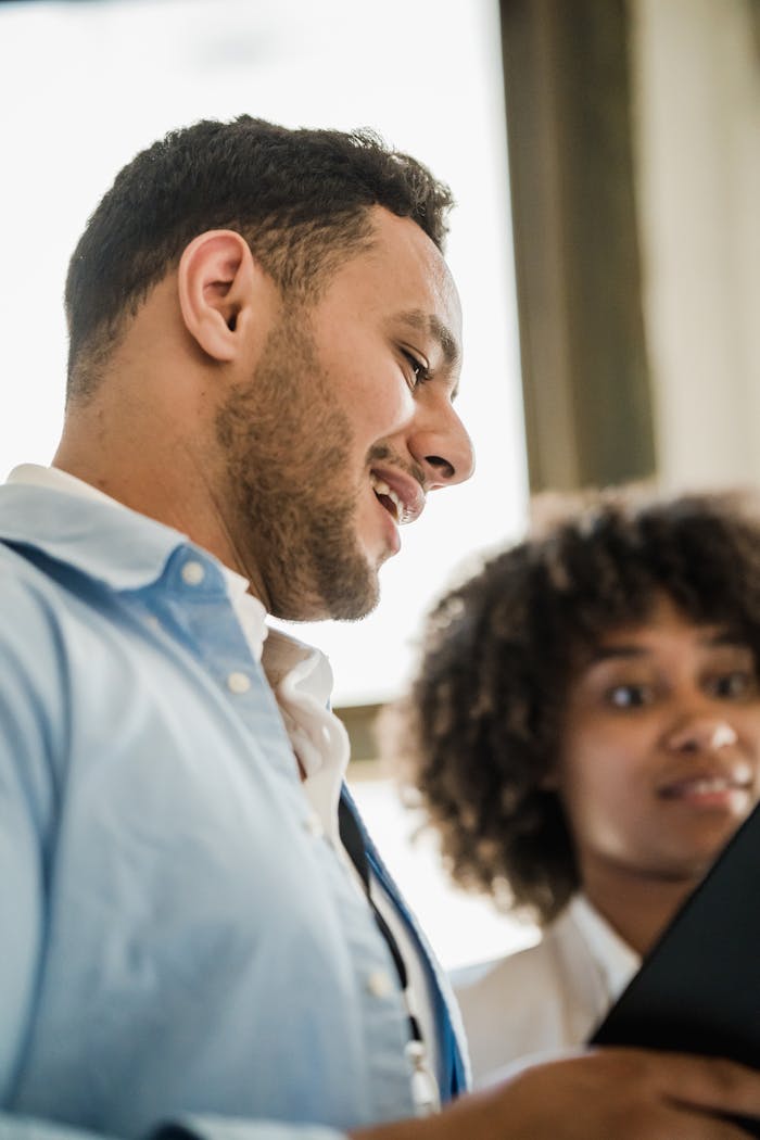 Home A man and woman engaging in a lively conversation in a modern office setting.